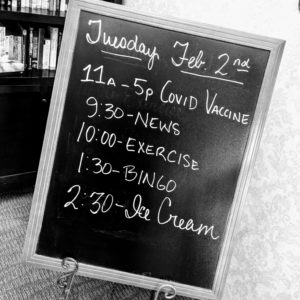 a schedule board with 11a-5p COVID Vaccine and 2:30 Ice Cream, among other things